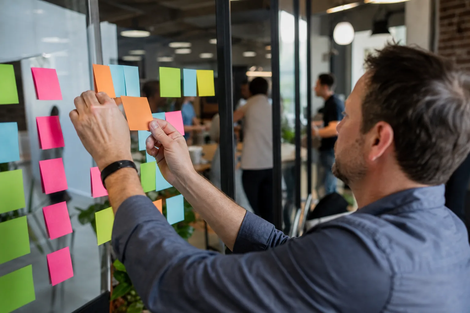 Team sorting fixes into columns of sticky notes on a glass wall