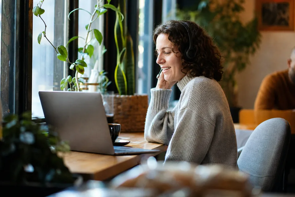 Customer success lead on a call, a customer profile open on her laptop