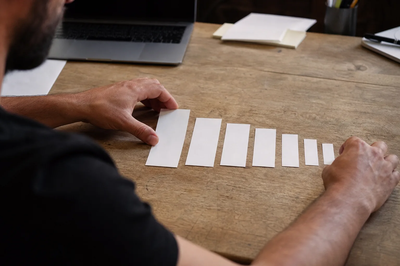 Growth analyst laying out paper cards in a narrowing row, one card per signup step